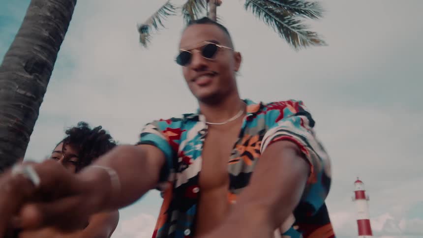 A man and woman dance joyfully on a tropical beach