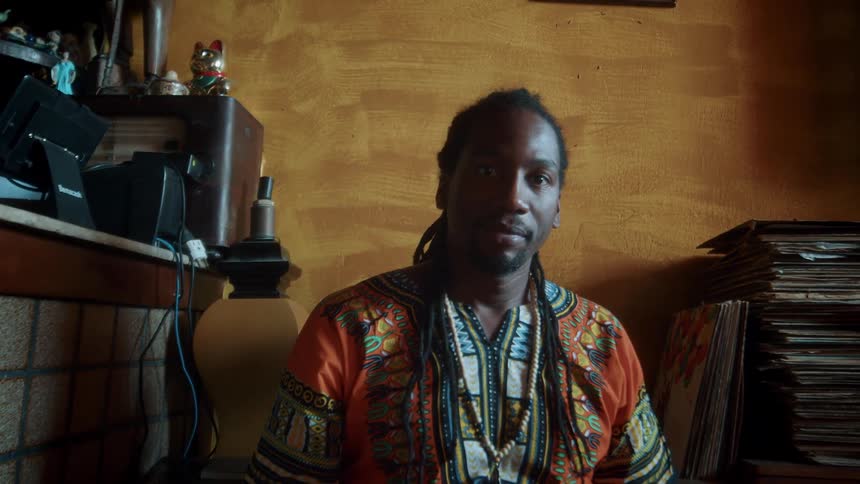 Portrait of young black man sitting in a room during daytime