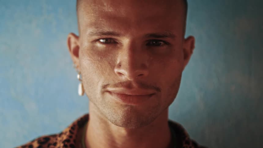Man giving a smile against a blue weathered wall background