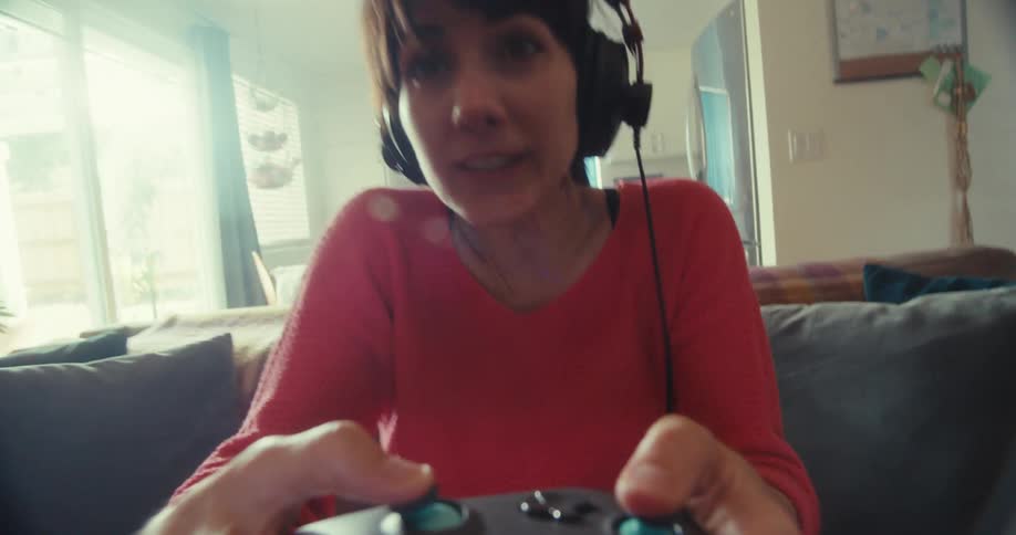 The woman moves the controller all around while playing a video game