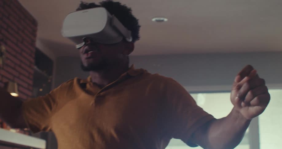 A man actively plays with a vr headset in a cozy living room