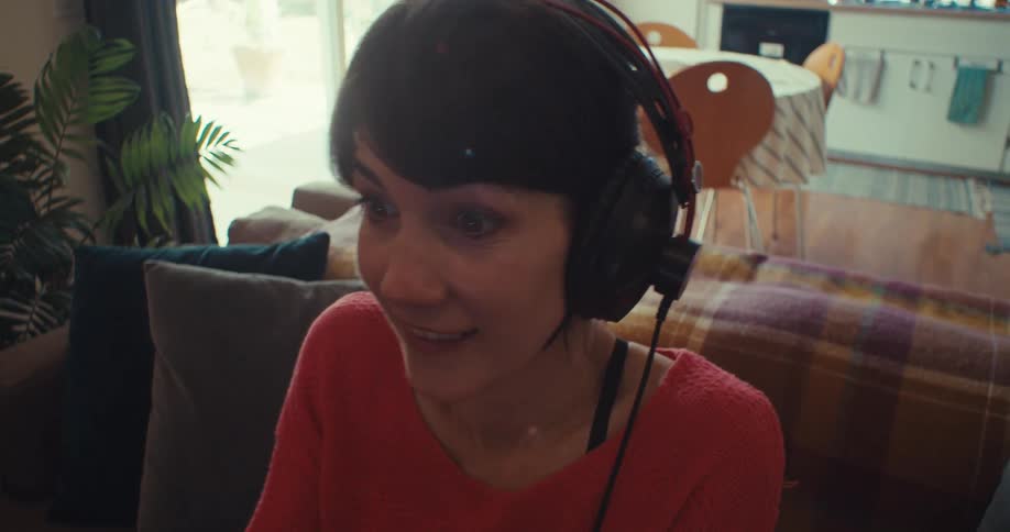 The woman moves around and smiles while playing a video game
