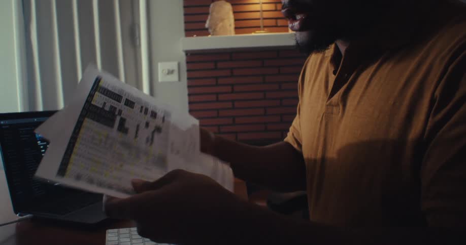 Man analyzes financial data at desk with charts and reports