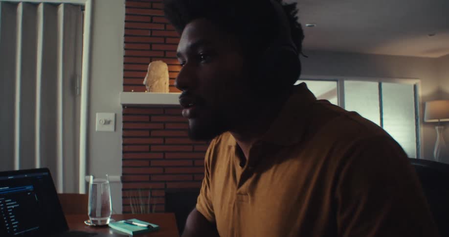 Man analyzes stock data while working at a computer in a cozy home office