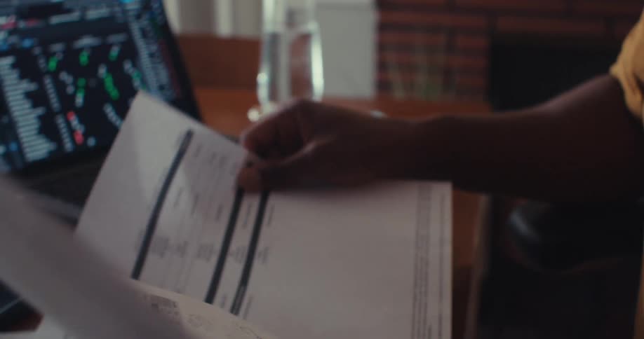 The man shuffles the papers on his desk