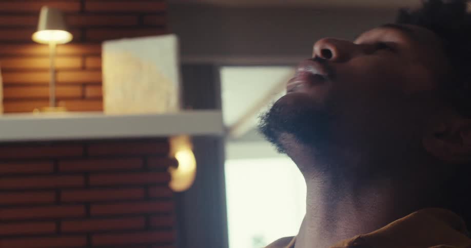 Reacting to something on his screen at home a man goes from frustration and stress to triumphant fist pumping celebration