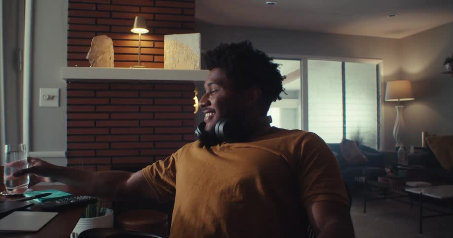 Man leans back smiling relaxing with headphones in a cozy room
