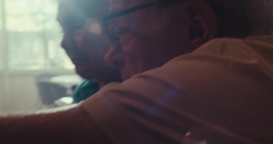 An elderly couple looks at a graph on their computuer