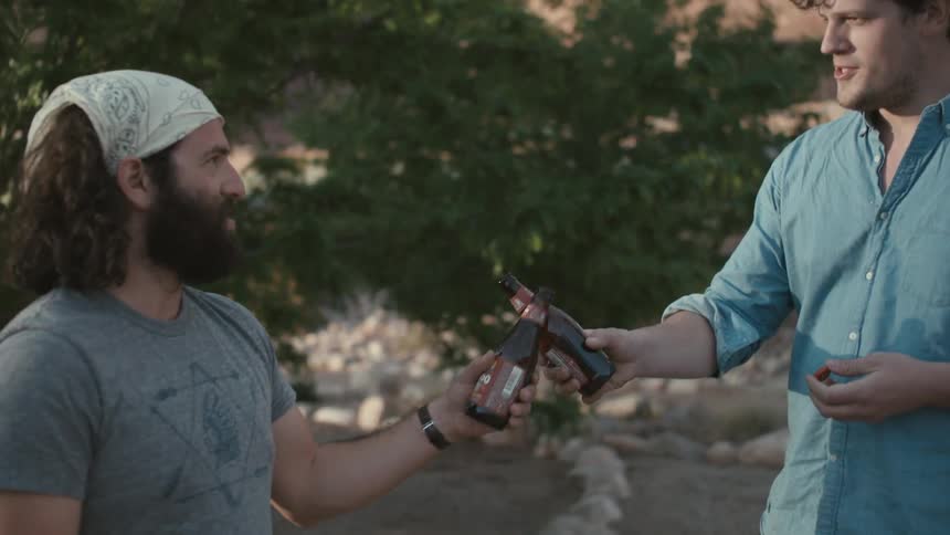 Two men drink beer and cheers each other