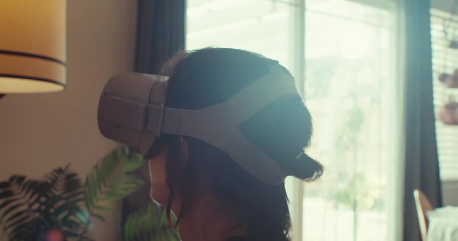 Woman standing in her living room looks around while using a virtual reality headset
