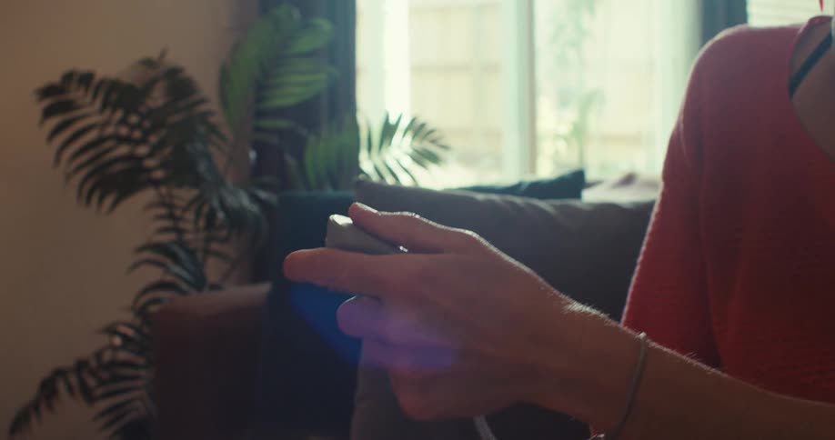 A young woman enjoys using a vr headset in a brightly lit living room