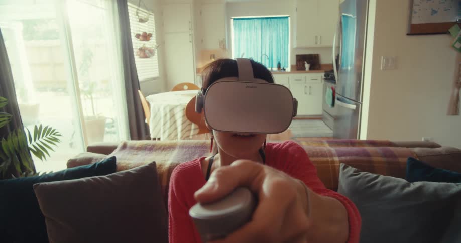 Woman sitting using virtual reality glasses in a room of the house