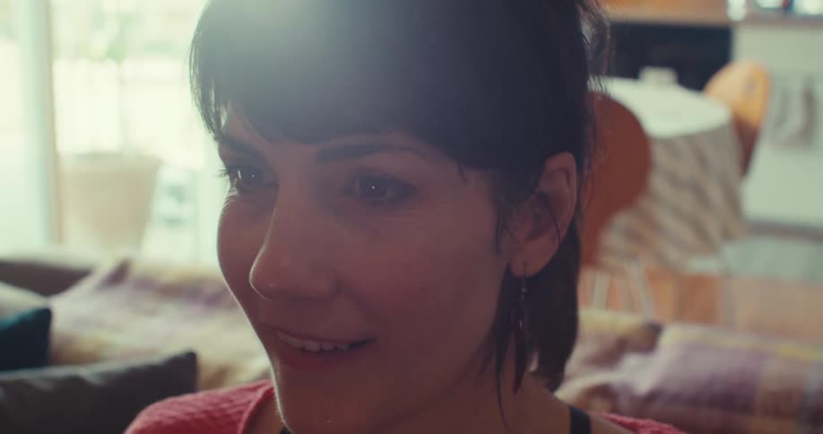 A woman smiles while holding a virtual reality headset