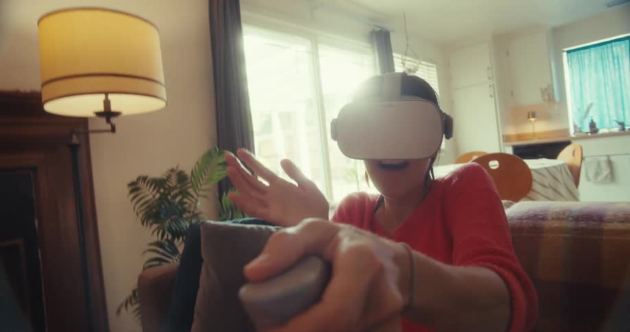 A person wearing a vr headset plays an immersive game in their living room