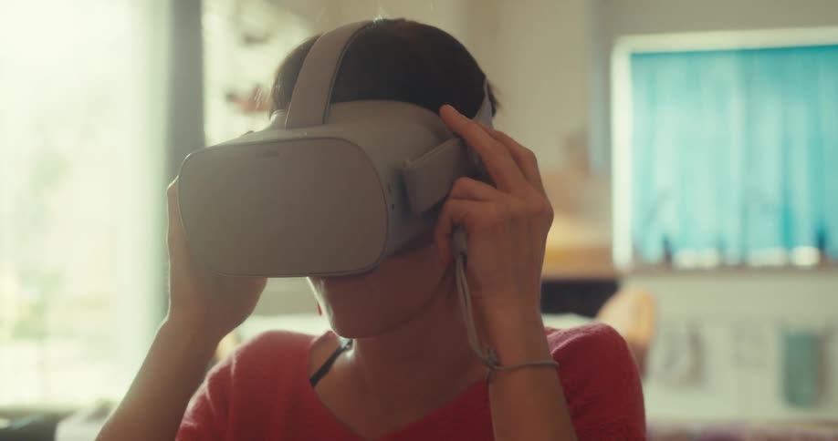 A woman takes off the virtual reality headset
