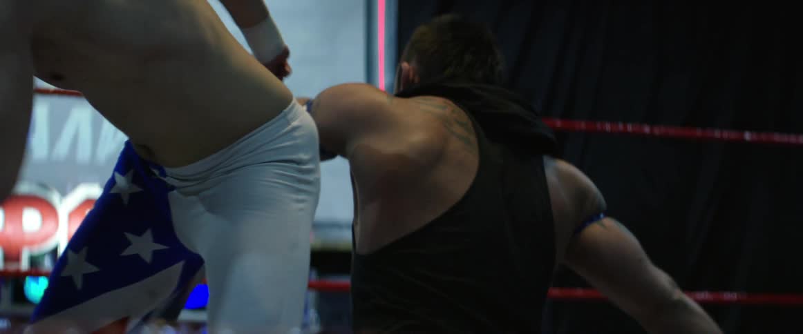 A wrestler kicks another wrestler in the head