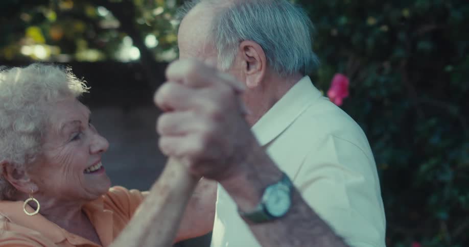 An elderly couple dances