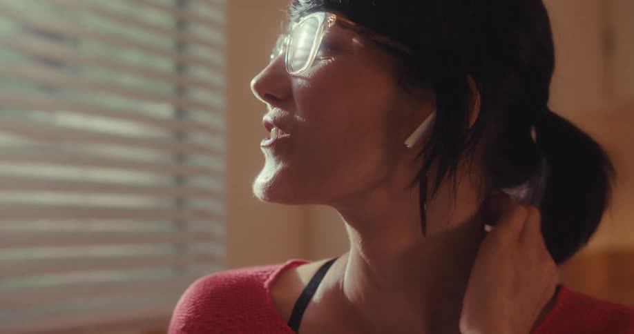 A woman in a room talking to someone first happy and then tired