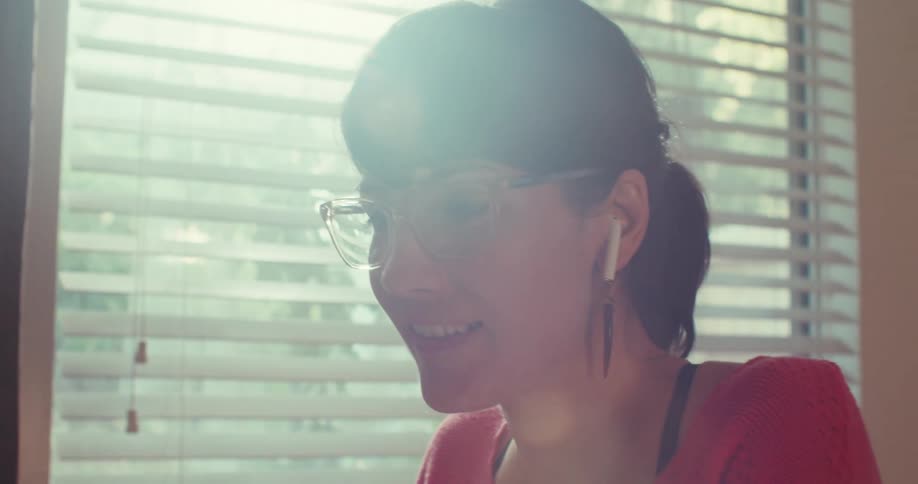 A woman is laughing and using a stylus