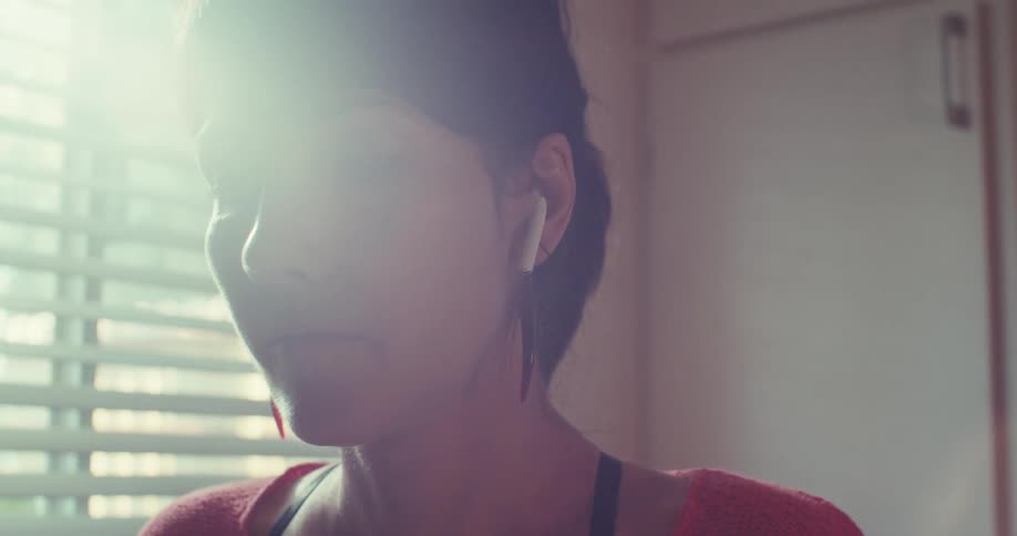 The woman puts in earbuds