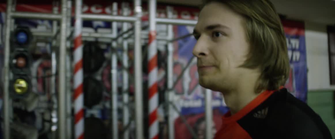 Two young men walk away from a fighting ring in a gym