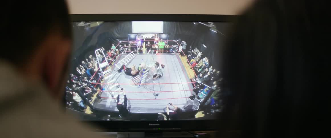 People watch a wrestling match on a television
