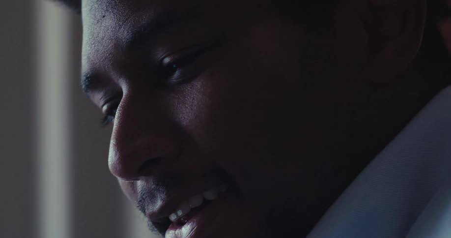 A close up of a man handling documents next to a laptop on a dimly lit office
