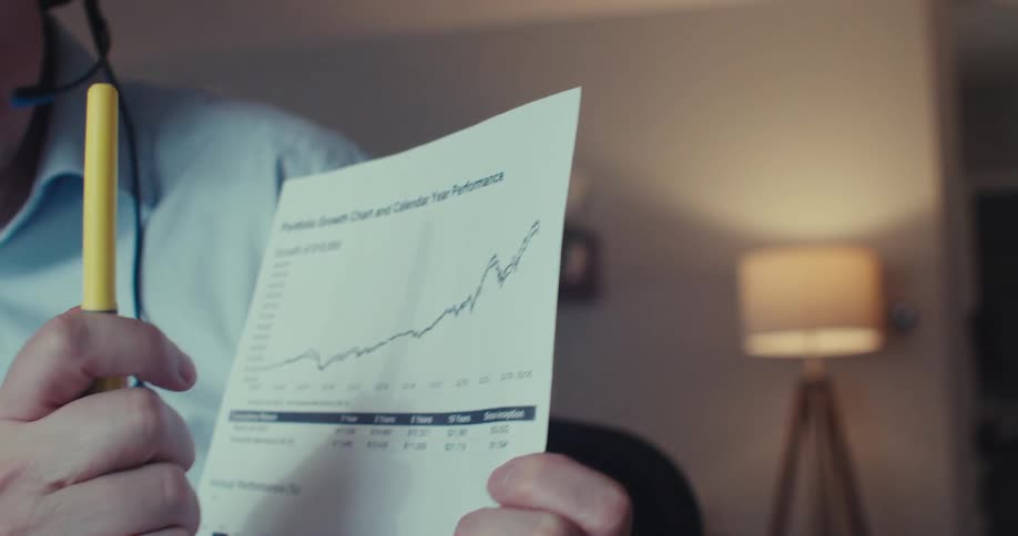 A man on a business call refers to a document