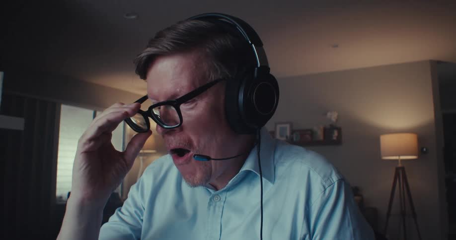 The man smiles and takes his glasses off