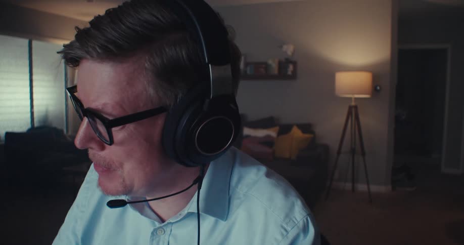 The man is talking into his microphone in front of the computer