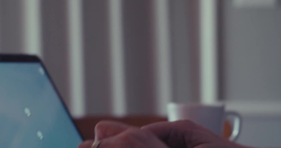 Close up of a man wearing a headset while working on a laptop at a desk