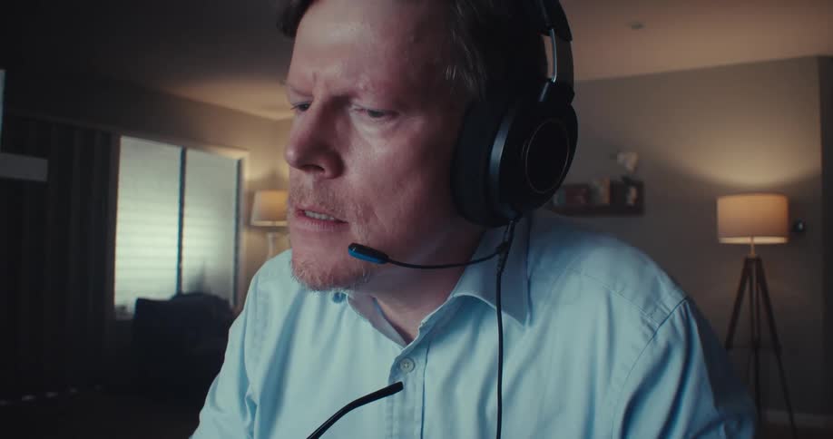 The man wearing headphones is wearing glasses then takes them off and looks thoughtful