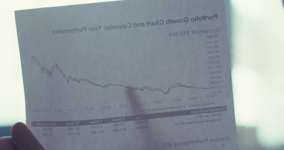 The man talks on his microphone and points to a paper