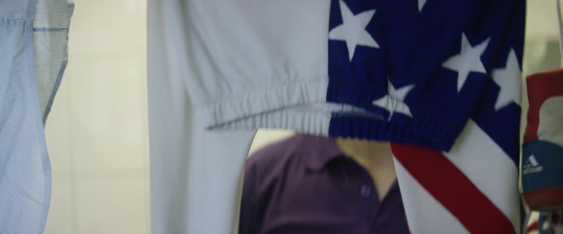 A man hangs up leotards that have an american flag pattern on them