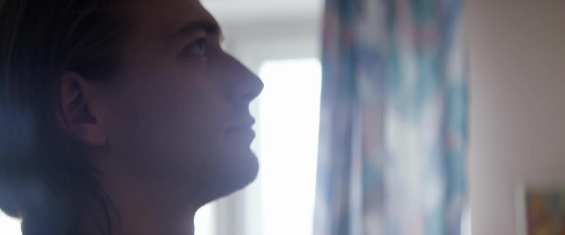 A man looks upward in a bright room