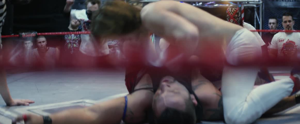 A wrestler hits the other with a belt and tries to pin him