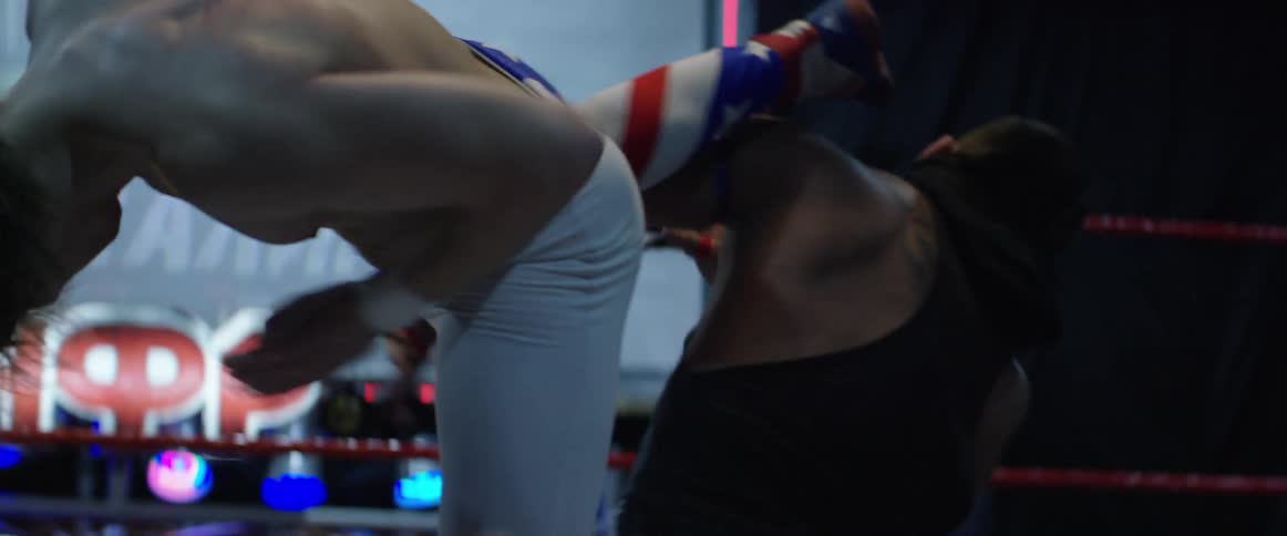 A wrestler jumps up and kicks his opponent in the head