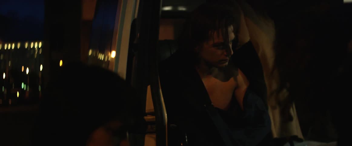 A person is sitting in a vehicle at night