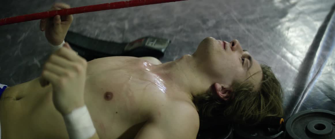 A man is lying in the ring breathing heavy