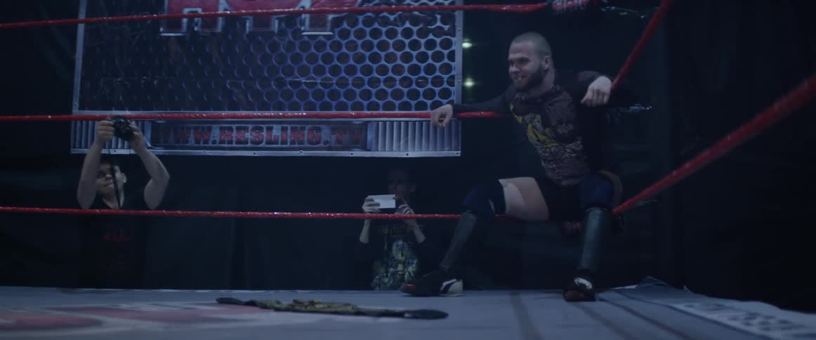 Wrestler leaning on the ropes in a ring