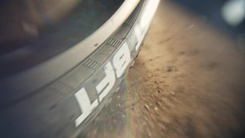 Bike wheel throws rocks as it spins out on gravel