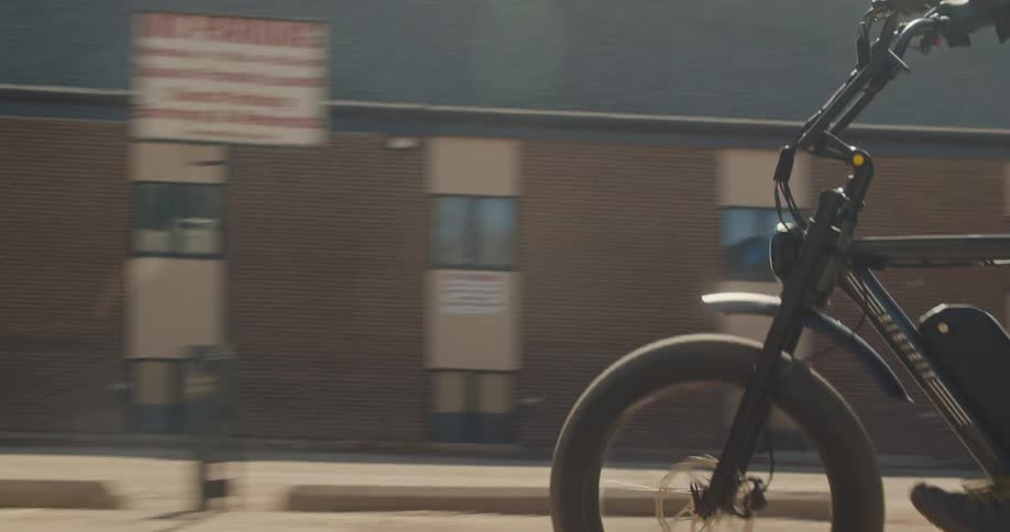 Man swerves through back alley on moped-style ebike