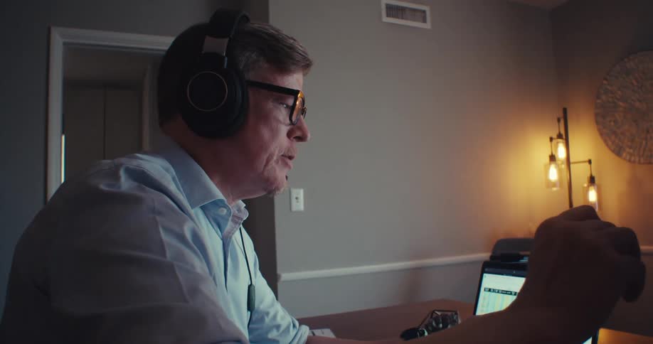 Man in headset analyzes stock charts on video call