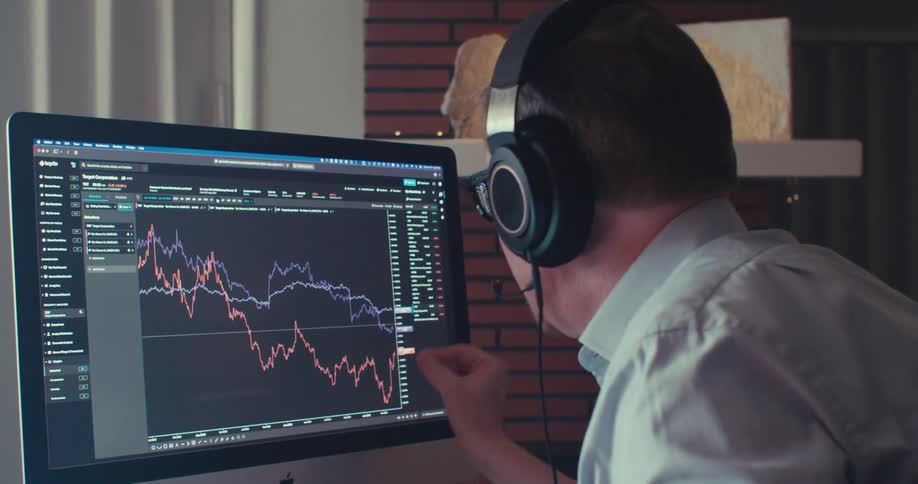 A man is on a business call looking at a graph
