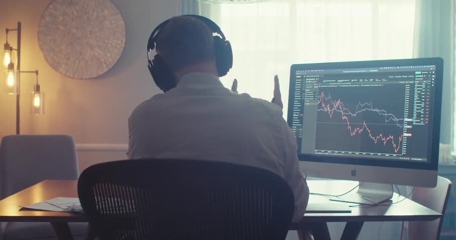 Man presents and analyzes stock market trends on a call from a home office setup