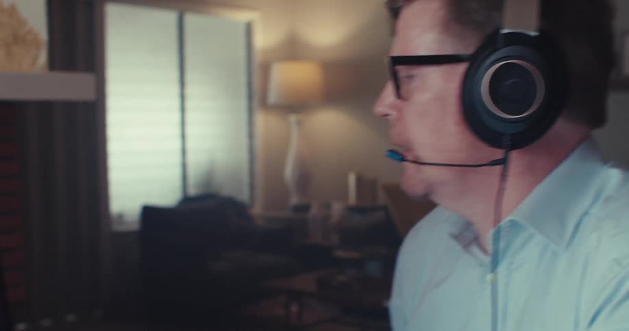 A man is on a business call looking at his computer