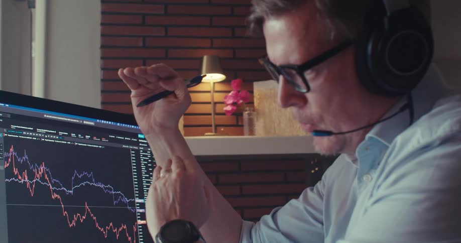 Man discusses stock trends during a video call in an office setting