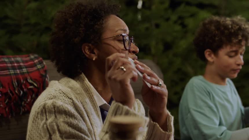 People enjoy a card game around a dinner table with food and drinks