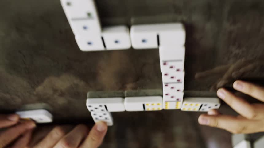 Upside down stone surface reflects people playing dominoes