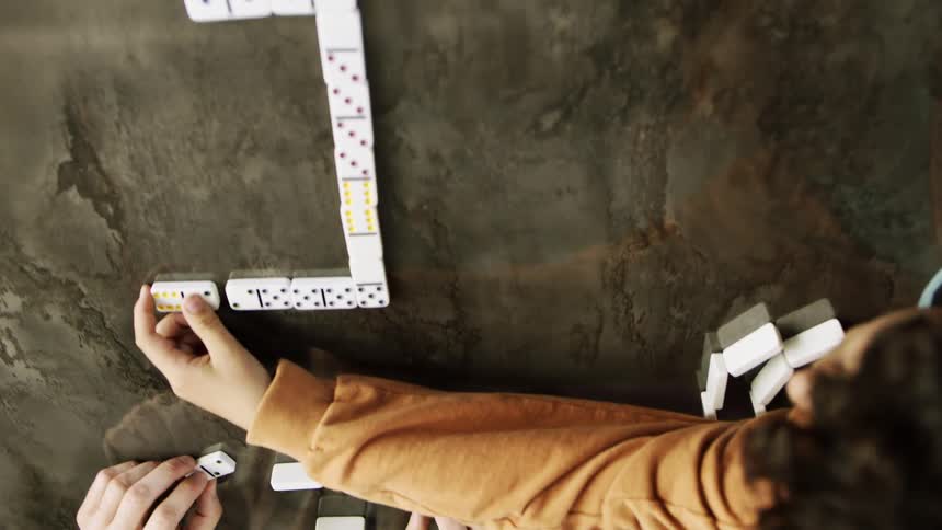 A father and son are playing a game of dominoes